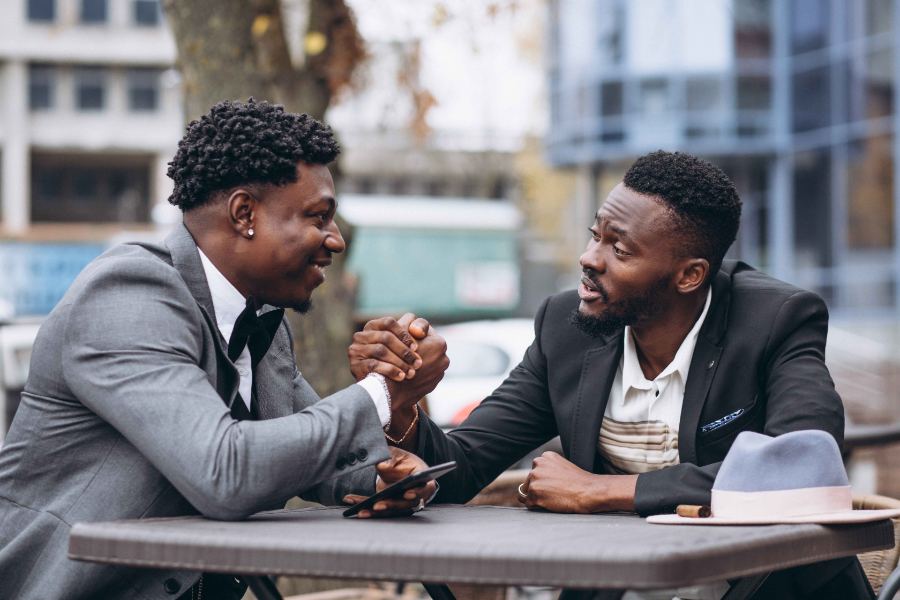 Two men sitting outside a cafe
